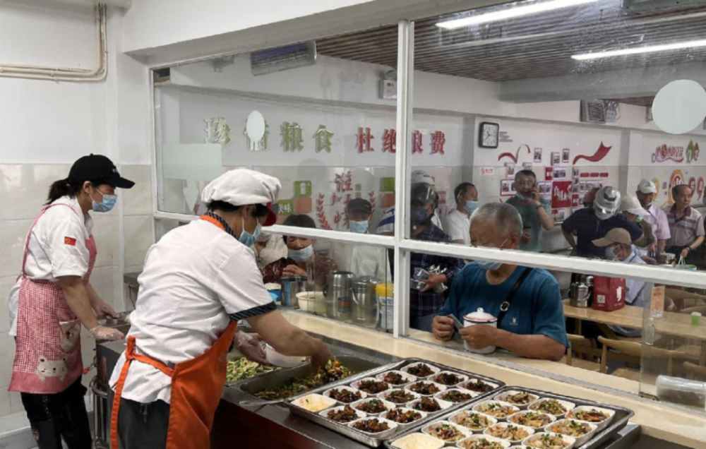 食堂菜香四溢,陆续有老人过来打包饭菜或堂食就餐,黄山学院的志愿者也